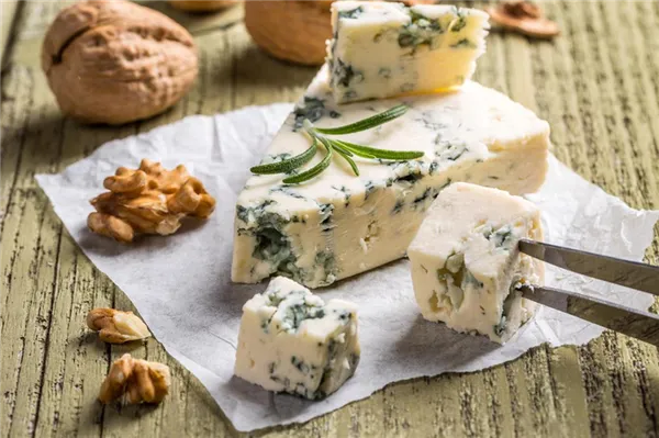 Нарезанный кубиком сыр «Горгонзола» с голубой плесенью, дополненный грецкими орехами