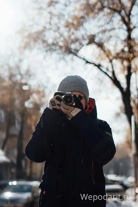 молодой человек фотографирует природу